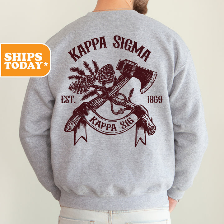 a man wearing a gray sweater with a hammer and pine tree on it