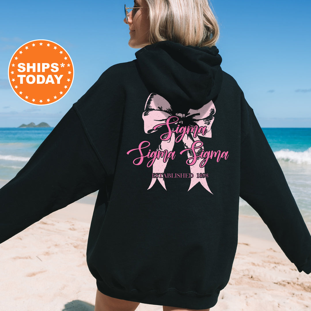 a woman in a black hoodie is walking on the beach