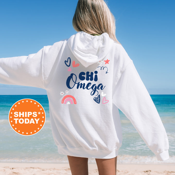 a woman standing on a beach wearing a white hoodie