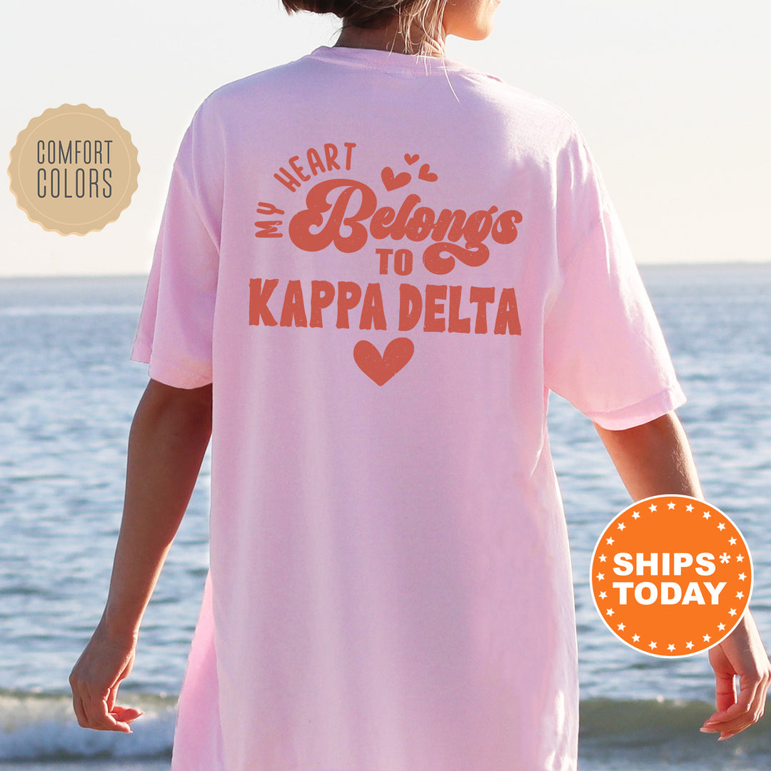 a woman wearing a pink shirt that says heart belongs to kapa delta