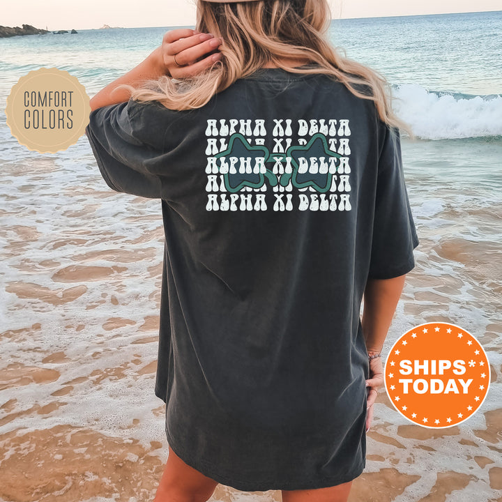 a woman standing on a beach wearing a black shirt