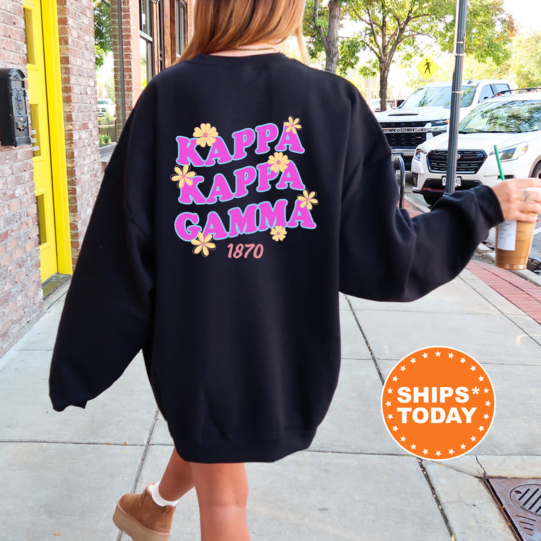 A person wearing a black sweatshirt with the text " Kappa Kappa Gamma" printed on it, walking down a sidewalk.