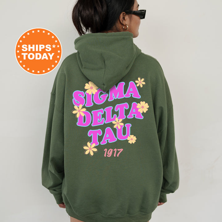 A person wearing a green hoodie with the text "SIGMA DELTA TAU" and "1917" printed on it.
