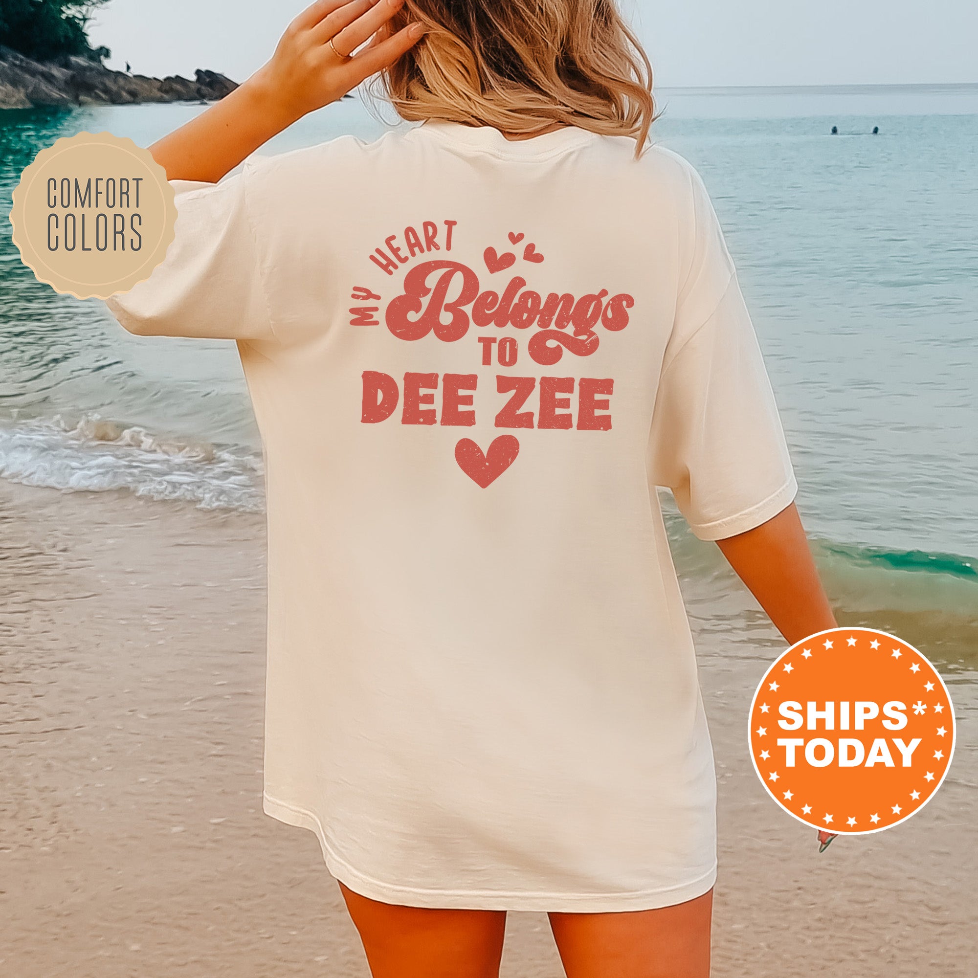 a woman standing on a beach wearing a white shirt