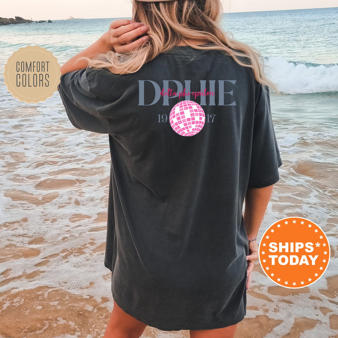 a woman standing on a beach wearing a black shirt