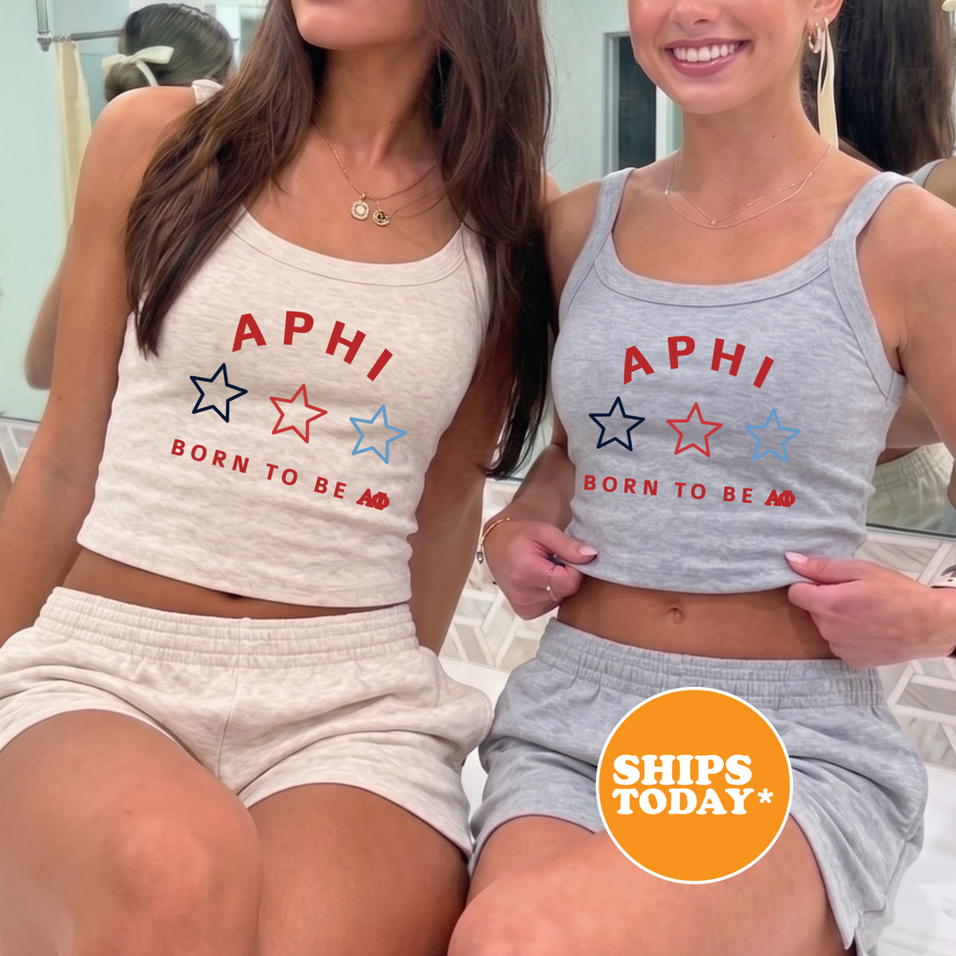Two women wearing matching tank tops with the text "APHI BORN TO BE A*" printed on them, posing together in front of a mirror.