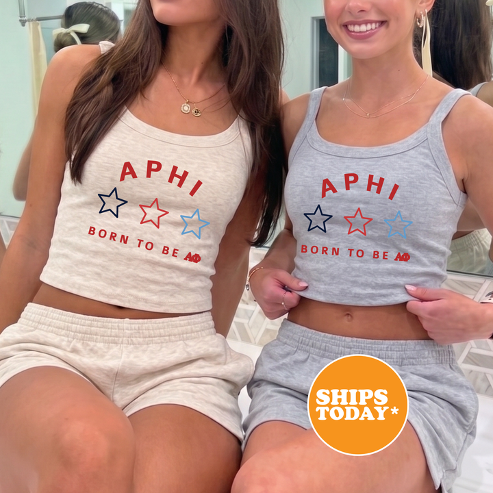 Two women wearing matching tank tops with the text "APHI BORN TO BE A*" printed on them, posing together in front of a mirror.