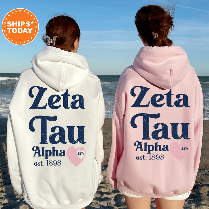 two women wearing matching sweatshirts on the beach