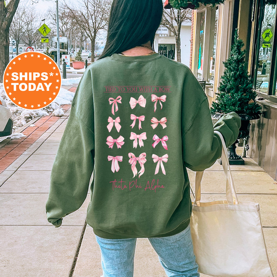 A person wearing a green sweatshirt with pink bows printed on it, walking on a sidewalk.