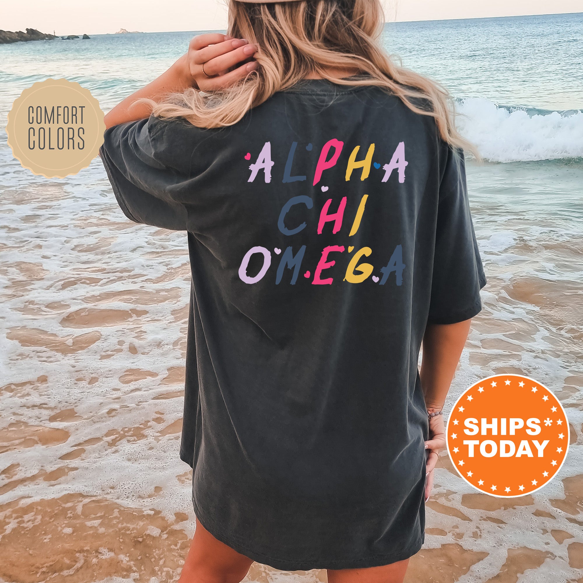 a woman standing on a beach wearing a black shirt