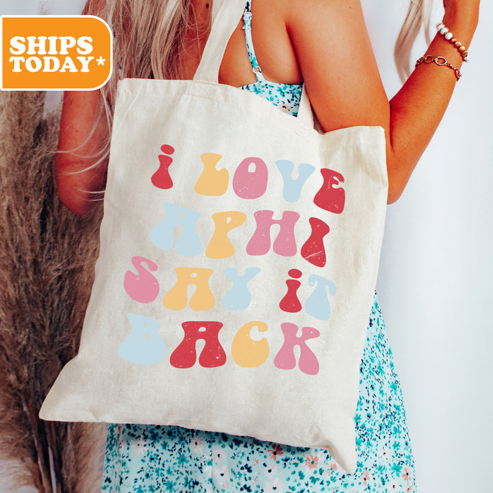 a woman holding a tote bag with a message on it