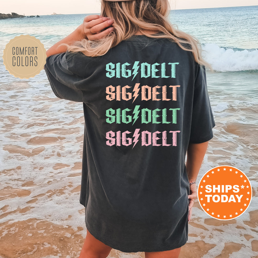 a woman standing on a beach wearing a black shirt