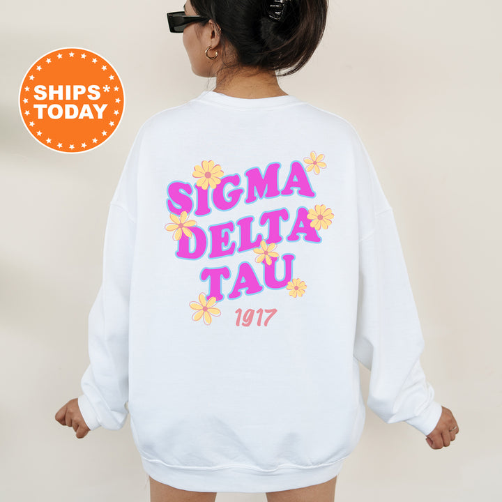 A woman wearing a white sweatshirt with the text "SIGMA DELTA TAU" and "1917" printed on it.