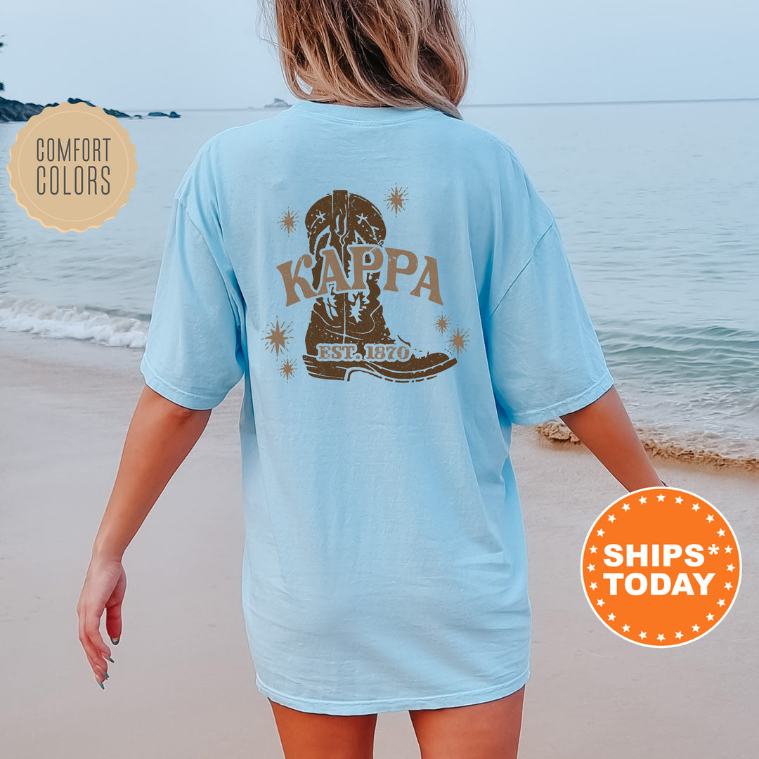 a woman walking on the beach wearing a blue shirt