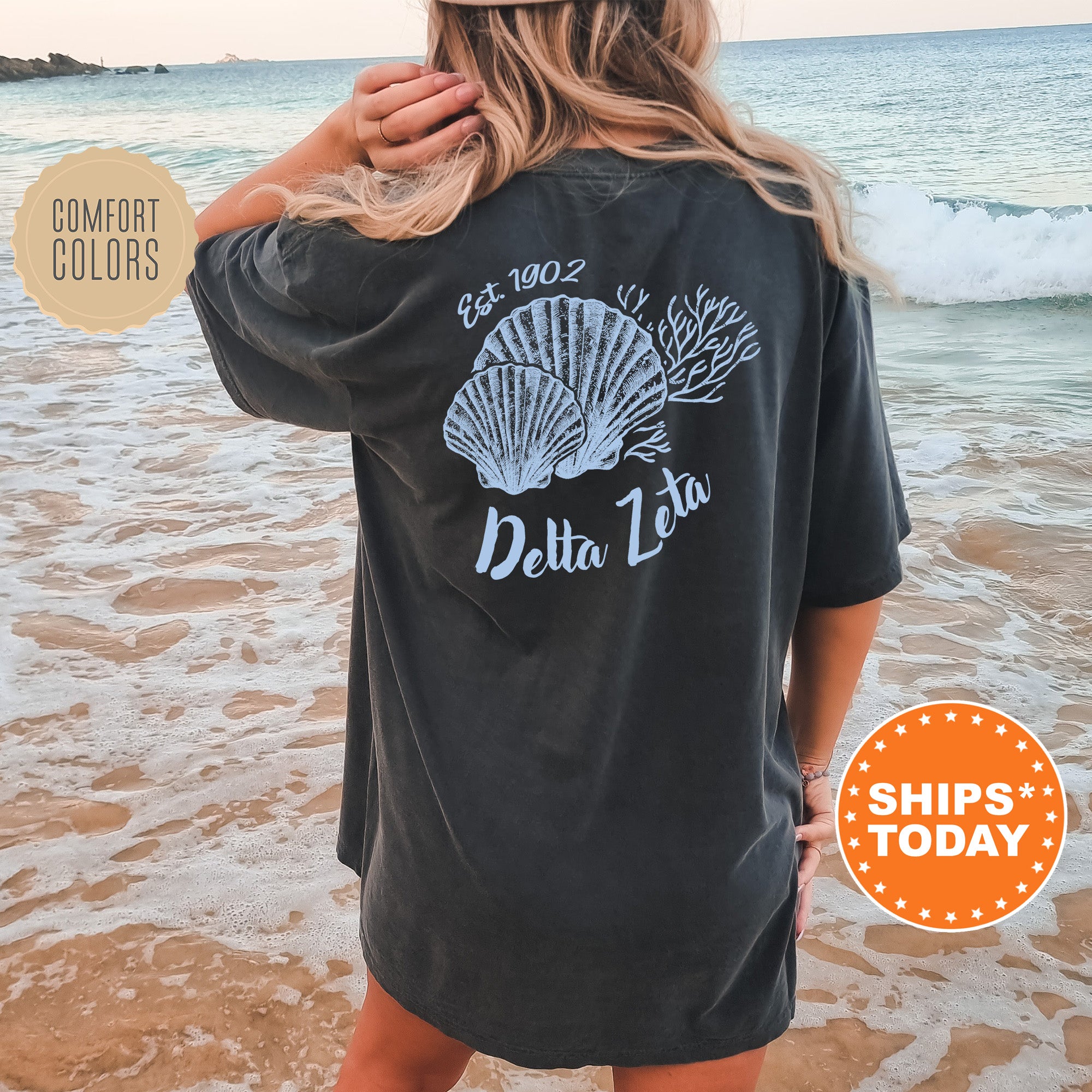 A woman wearing a black t-shirt with a graphic design of seashells and the text 