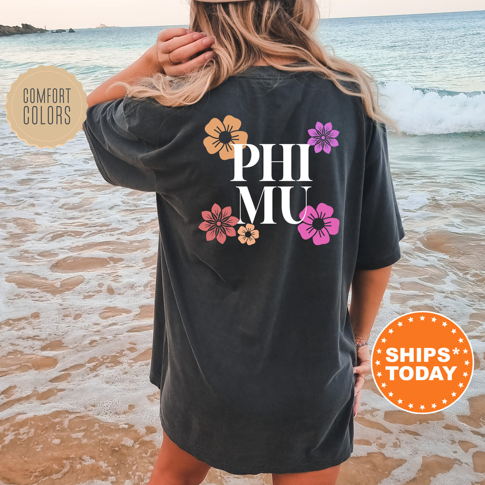a woman standing on the beach wearing a phi mu t - shirt