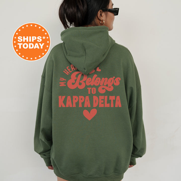 a woman wearing a green hoodie with the words kapa delta printed on it