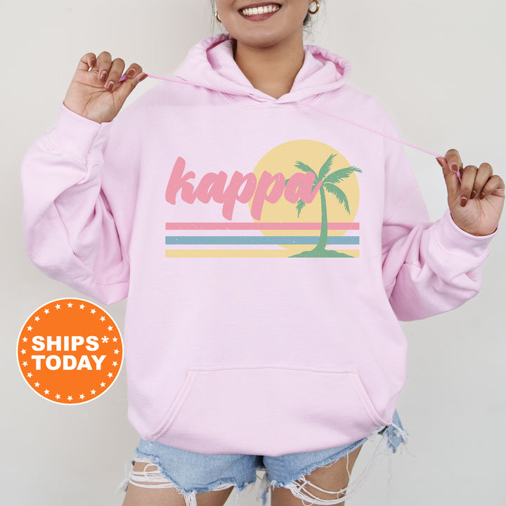 a woman wearing a pink hoodie with a palm tree on it