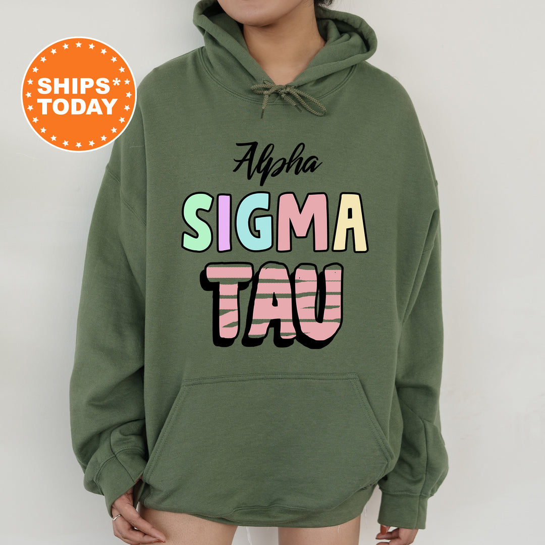 a woman wearing a green hoodie with the words stigmaa tau on it