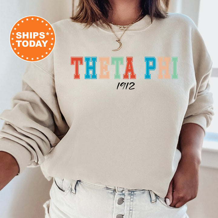 a woman wearing a sweatshirt that says theta pi on it