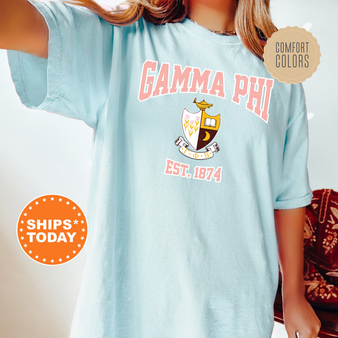 a woman wearing a light blue shirt with the words gama phi on it