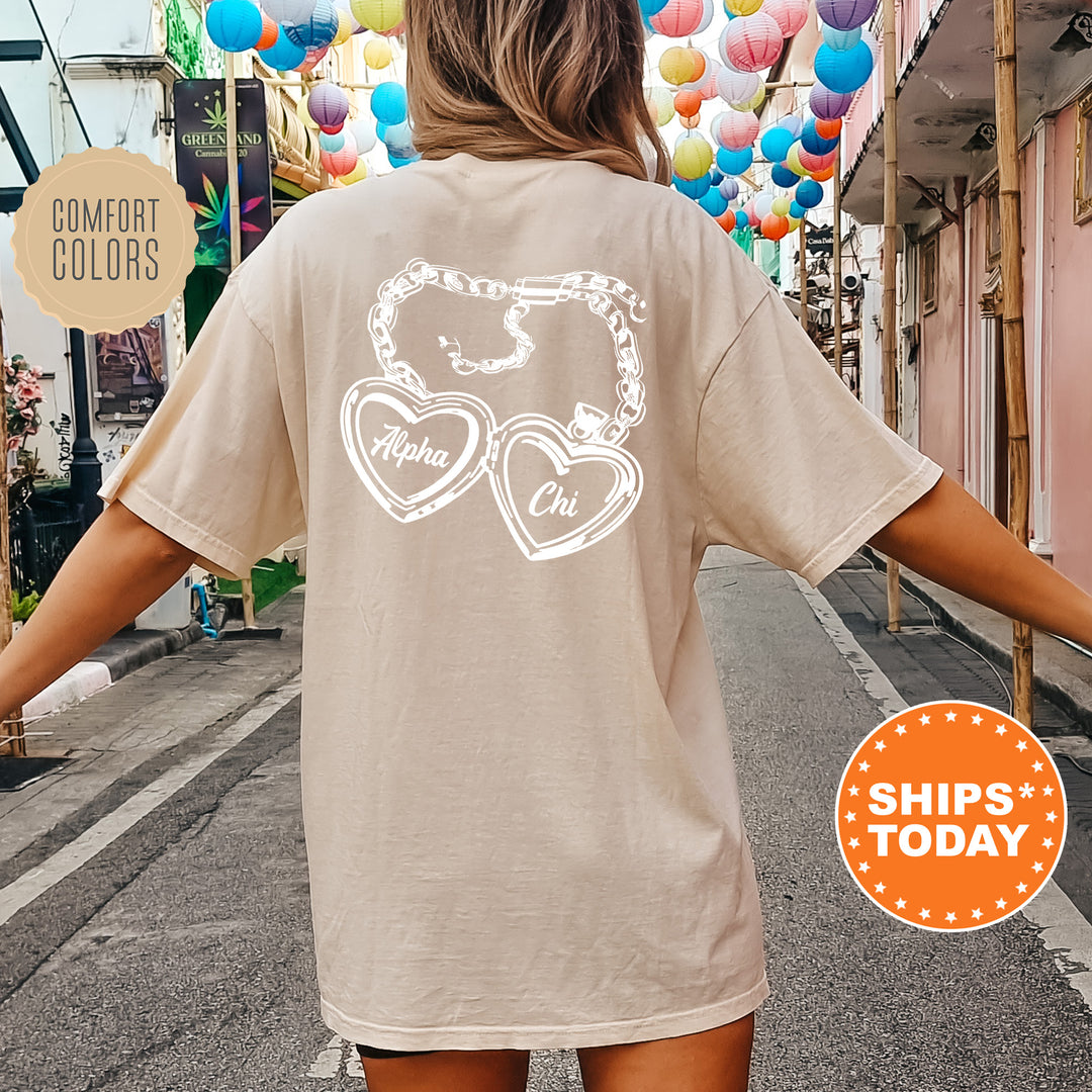 A person wearing a beige t-shirt with a graphic design on the back, standing on a street with colorful lanterns hanging overhead.