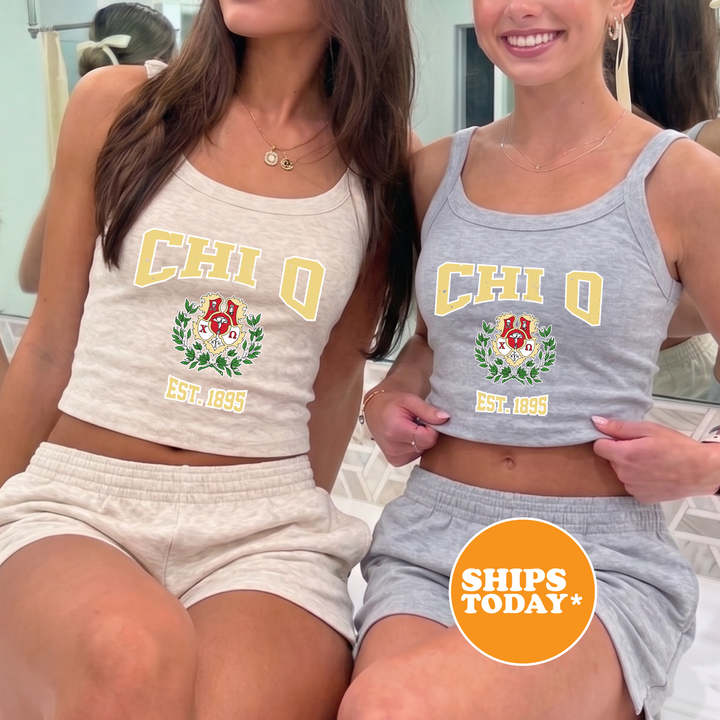 Two young women wearing tank tops with the letters "CHI" and "Q" printed on them, posing together in front of a mirror.