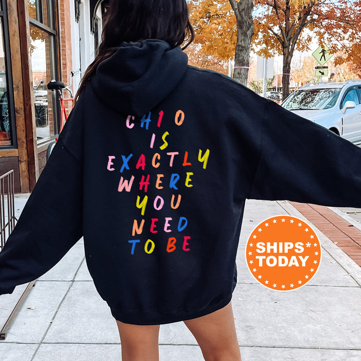 a woman wearing a black hoodie with colorful letters on it