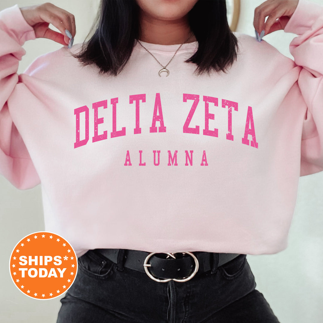 a woman wearing a pink sweatshirt with delta zeta on it