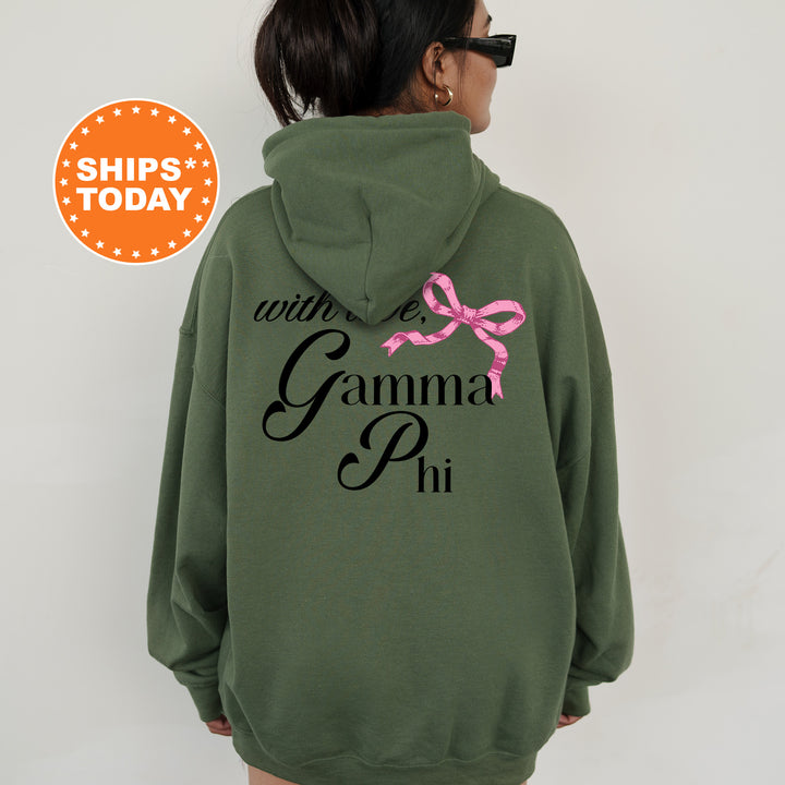 a woman wearing a green hoodie with a pink bow on it