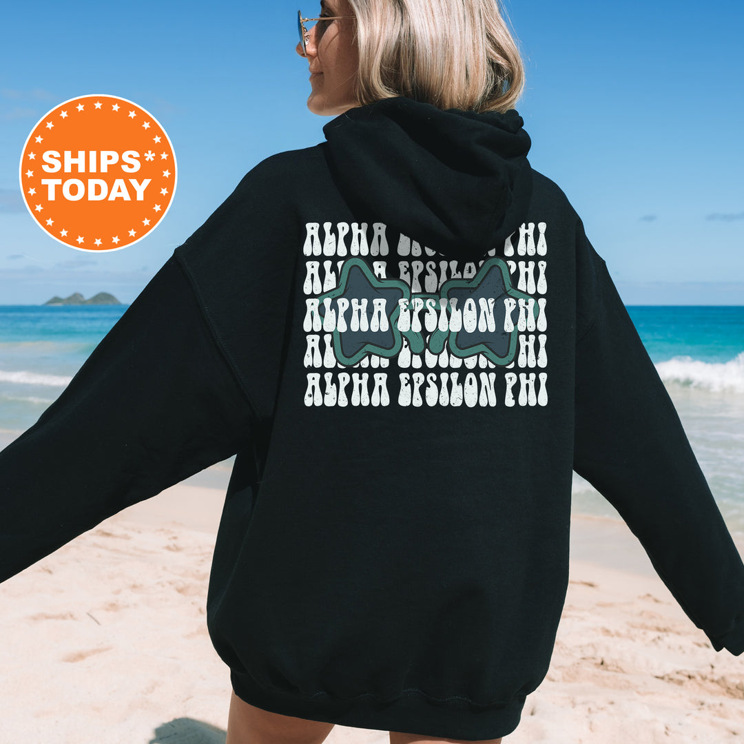 a woman in a black hoodie is walking on the beach