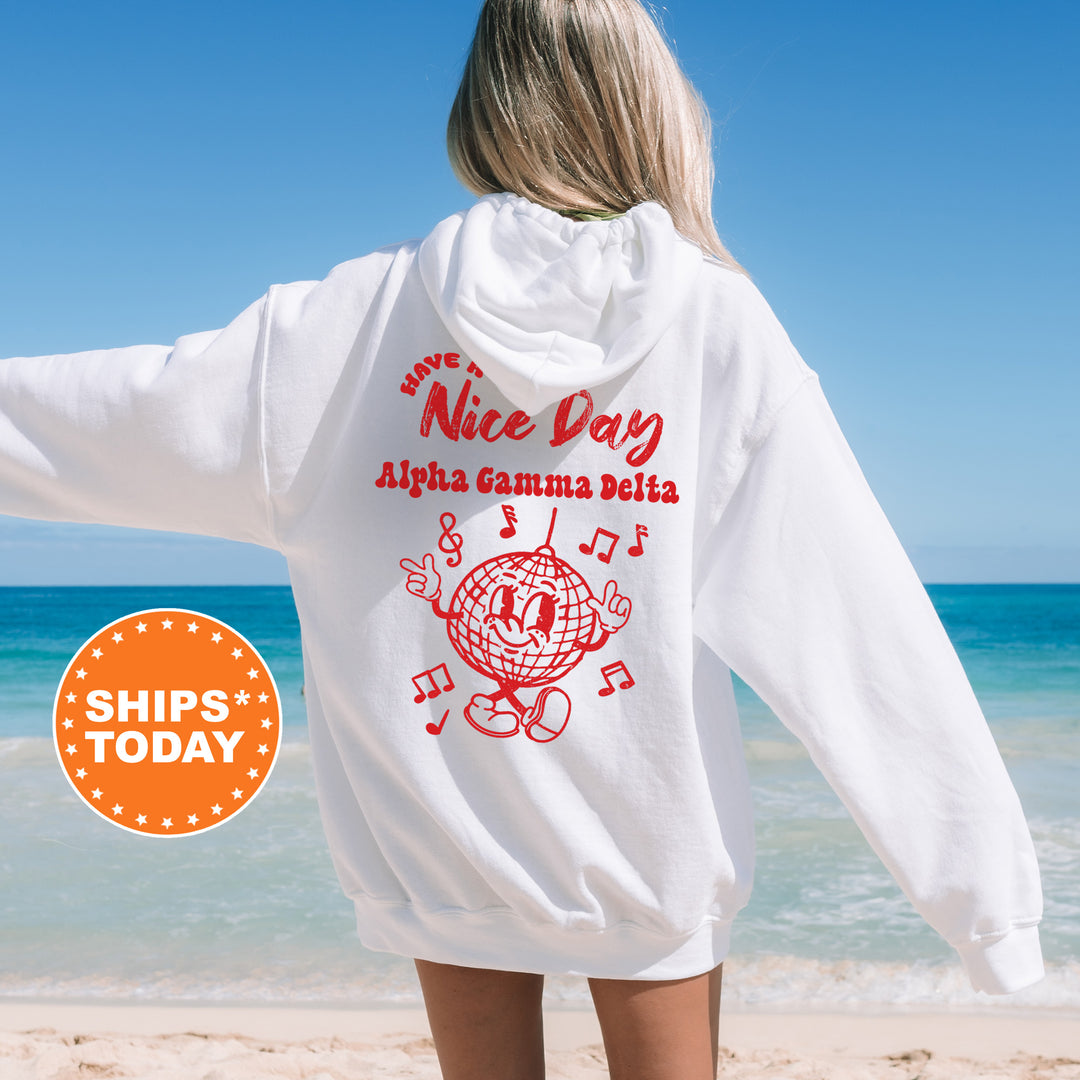 a woman standing on a beach wearing a white sweatshirt