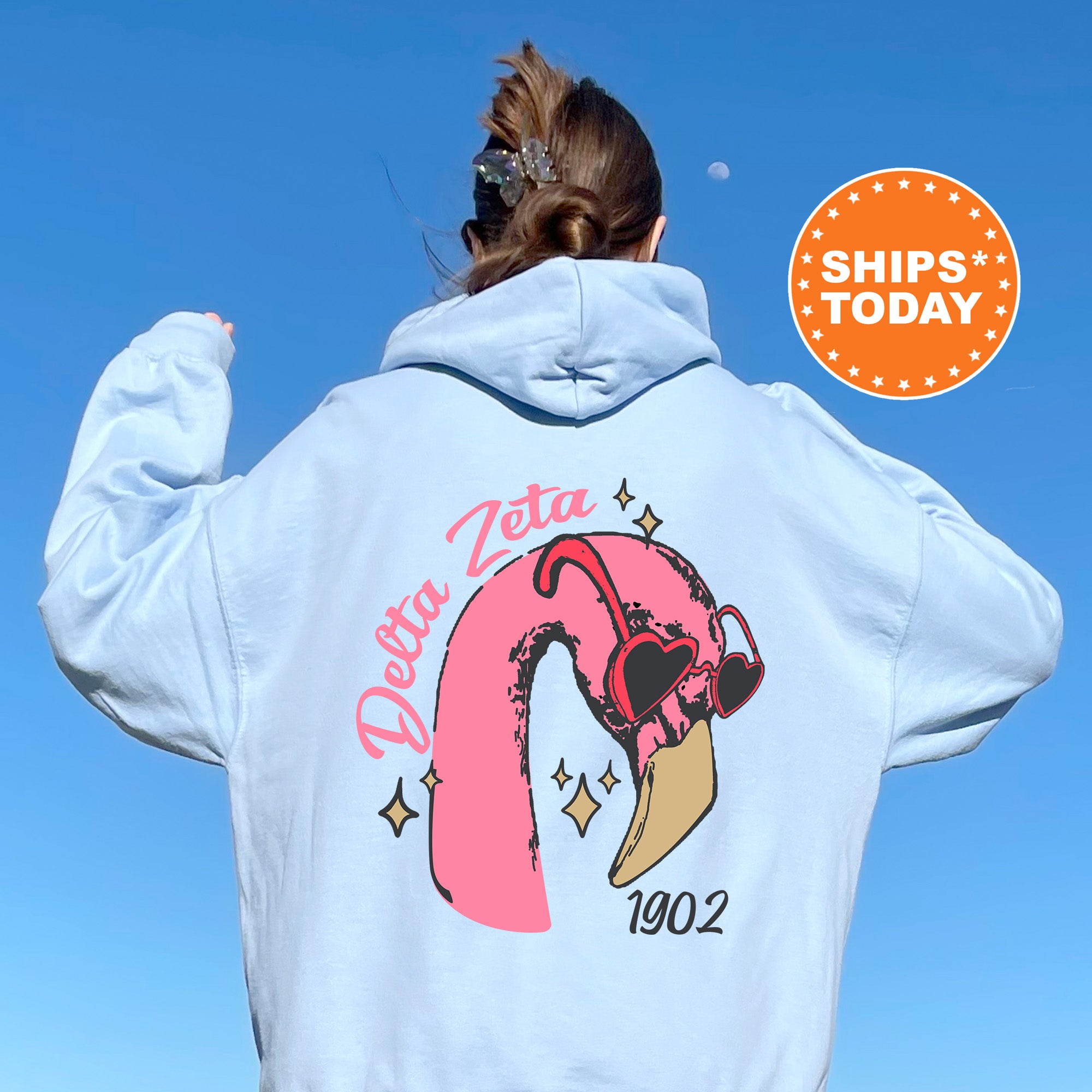 a woman wearing a white sweatshirt with a pink flamingo on it