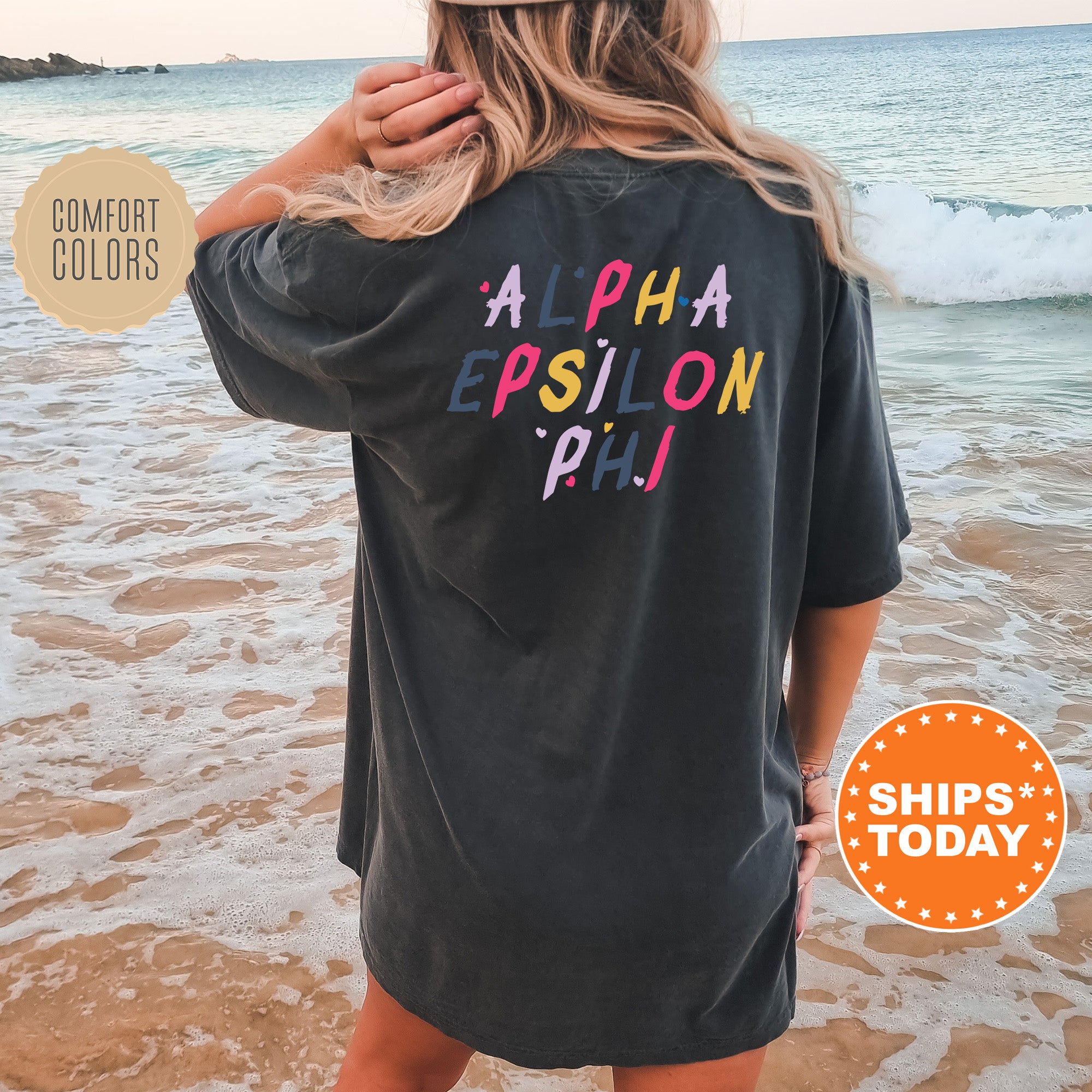 a woman standing on a beach wearing a black shirt