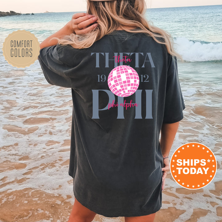 a woman standing on a beach wearing a t - shirt