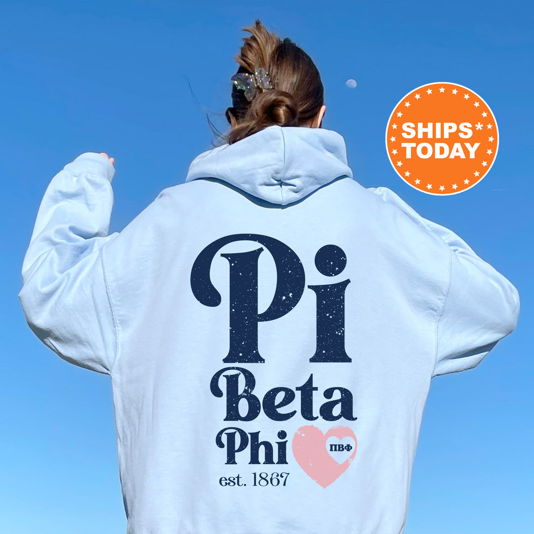 a woman wearing a white hoodie with the words pi beta phi on it