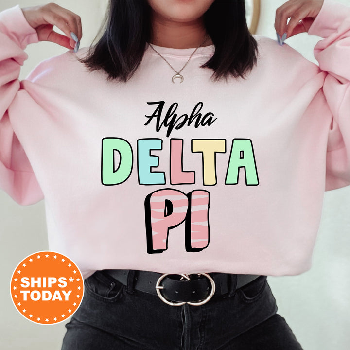 a woman wearing a pink sweatshirt with the words delta pi on it