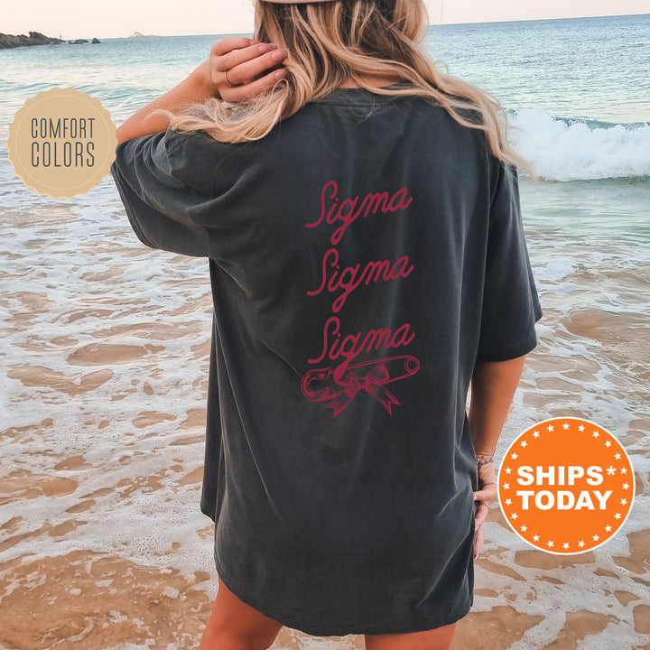 a woman standing on a beach wearing a black shirt