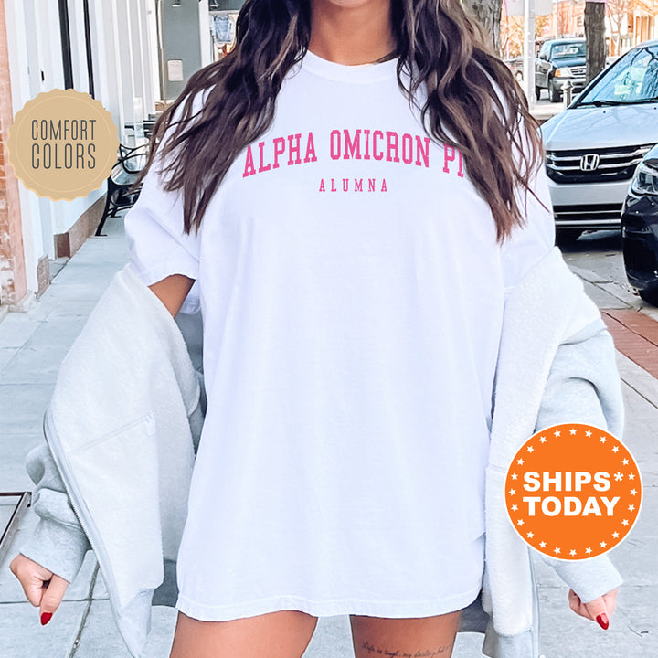 a woman wearing a white shirt with pink letters on it