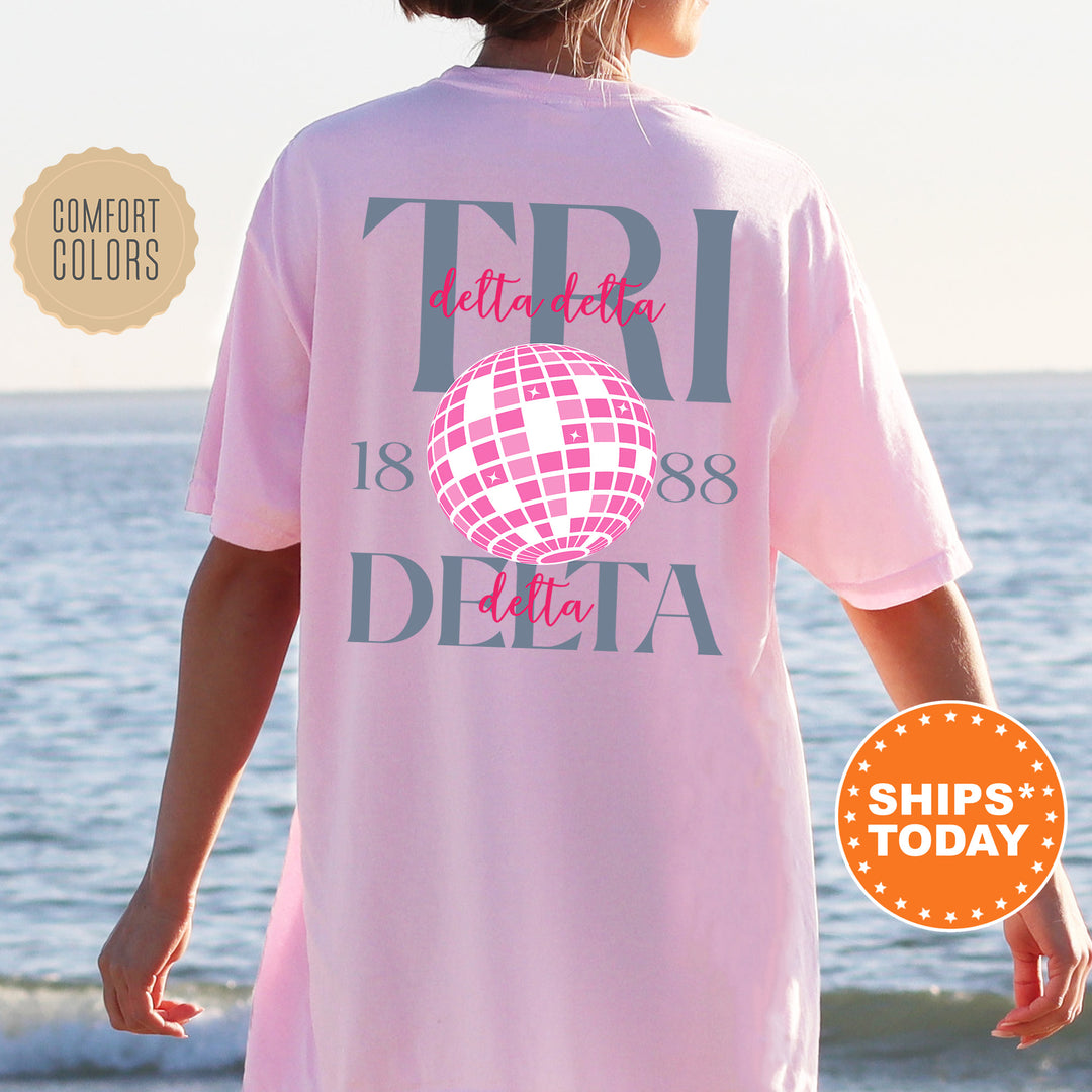 a woman wearing a pink shirt with a disco ball on it