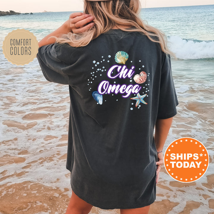 a woman standing on a beach wearing a shirt that says chi chi chi chi chi