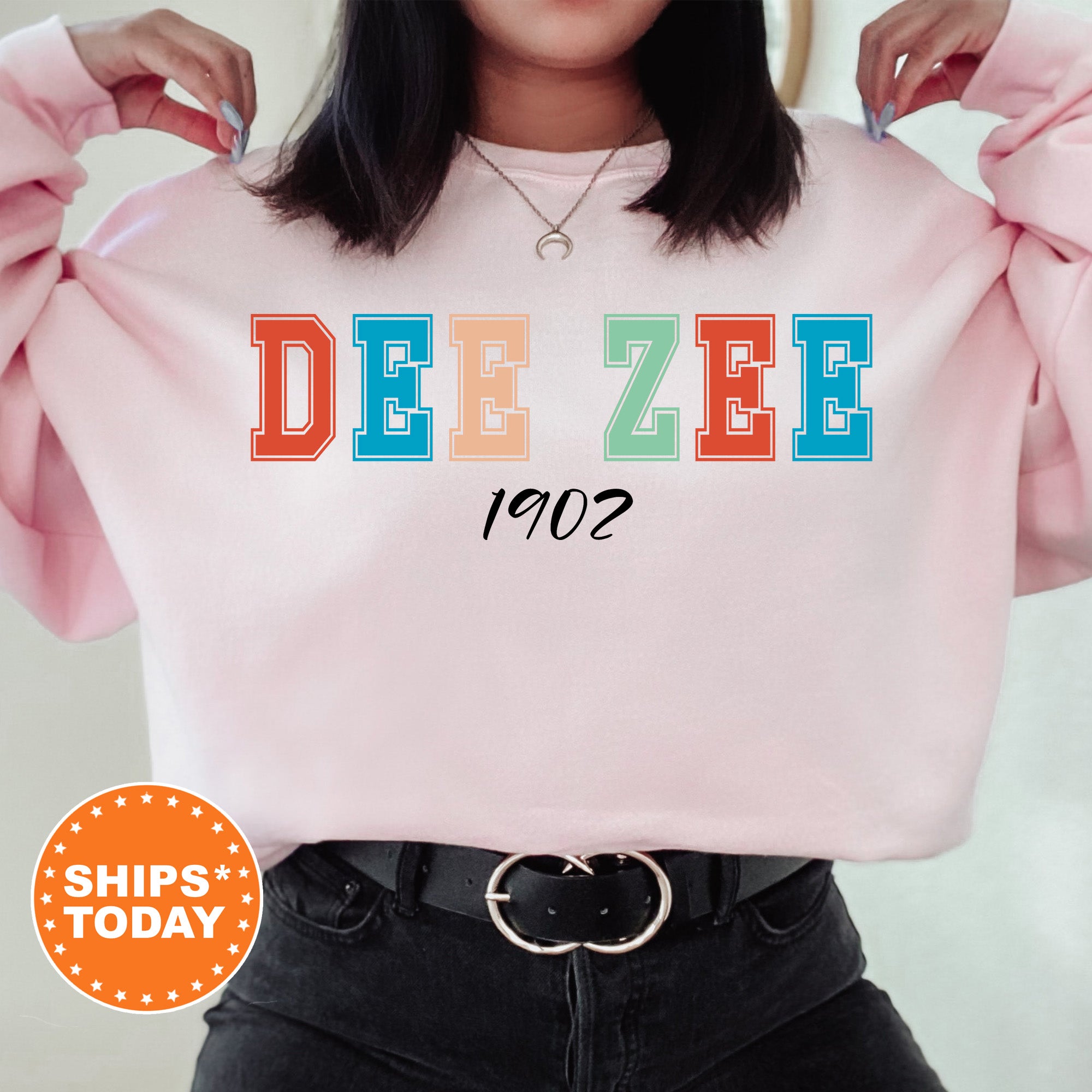 a woman wearing a pink sweatshirt with the word dee zeee printed on it