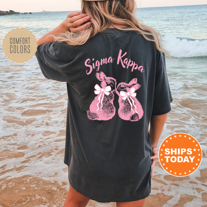 a woman standing on a beach wearing a black shirt