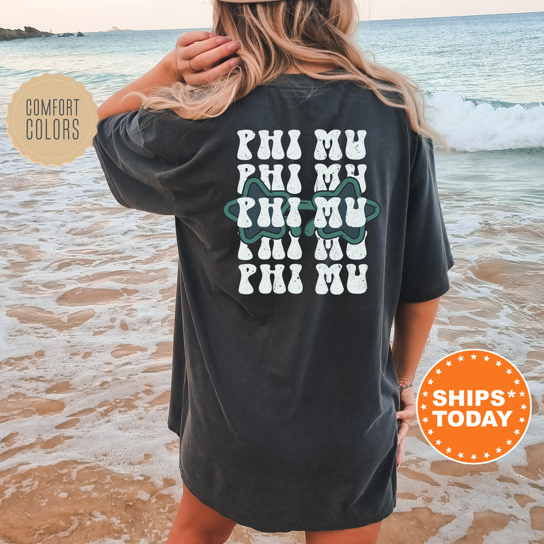 a woman standing on a beach wearing a black shirt