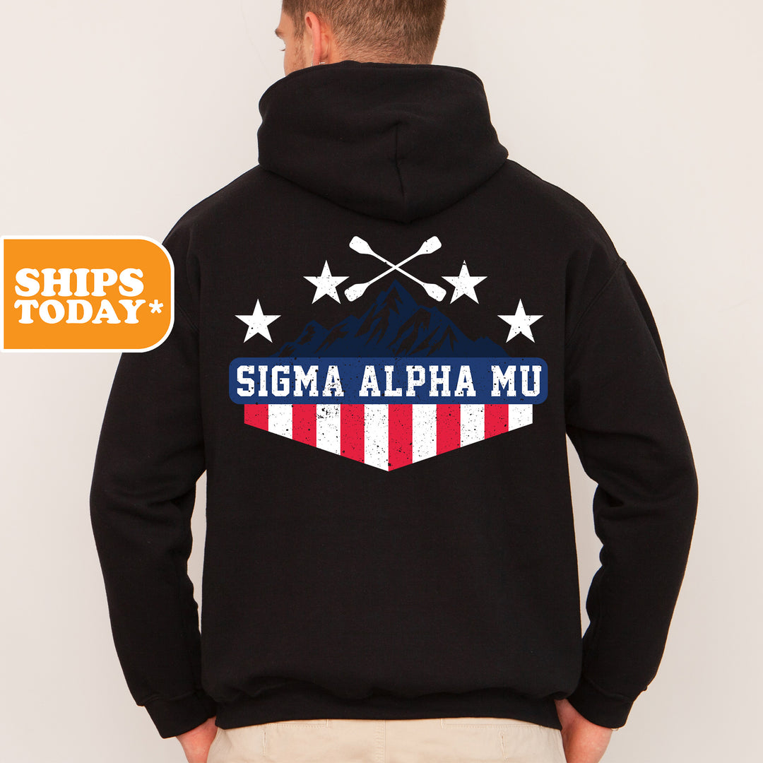a man wearing a black hoodie with a mountain and stars on it