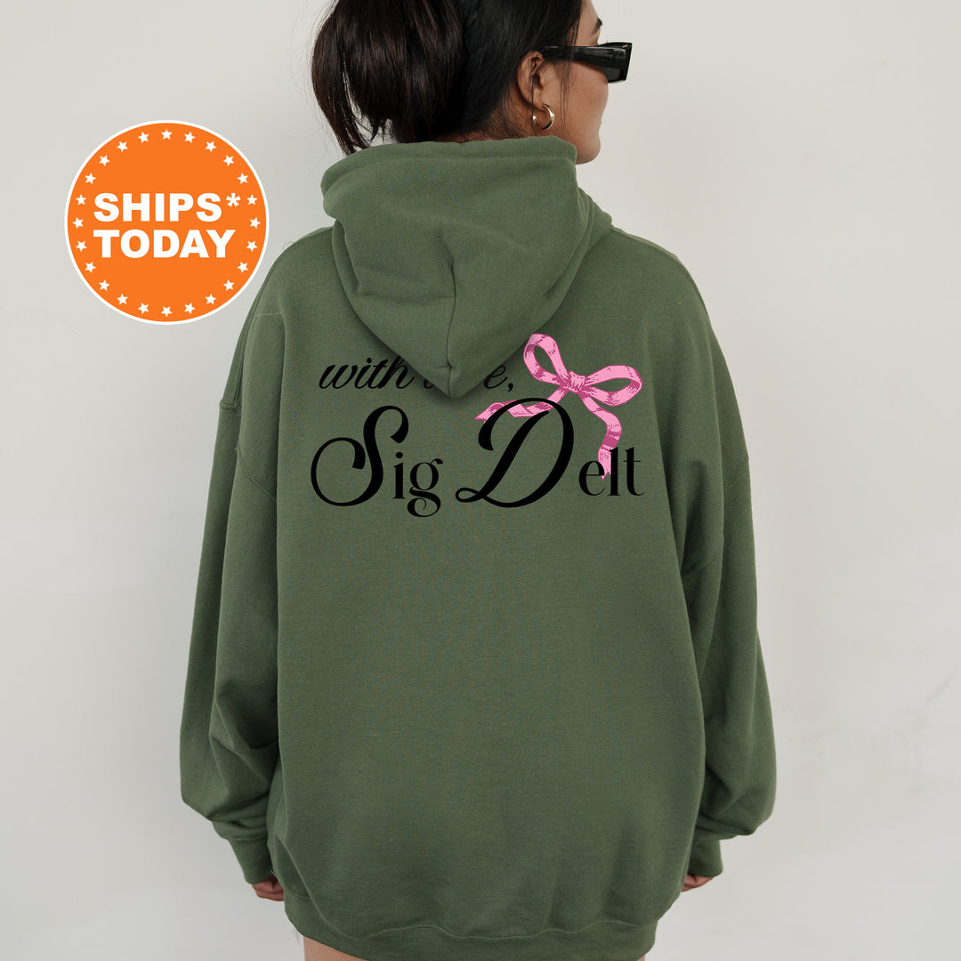 a woman wearing a green hoodie with a pink bow on it