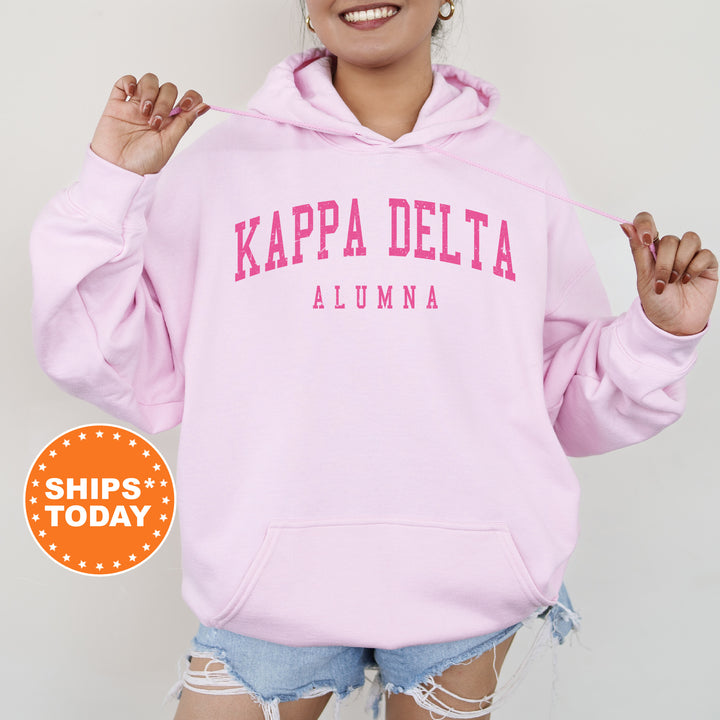 a woman wearing a pink kapa delta hoodie