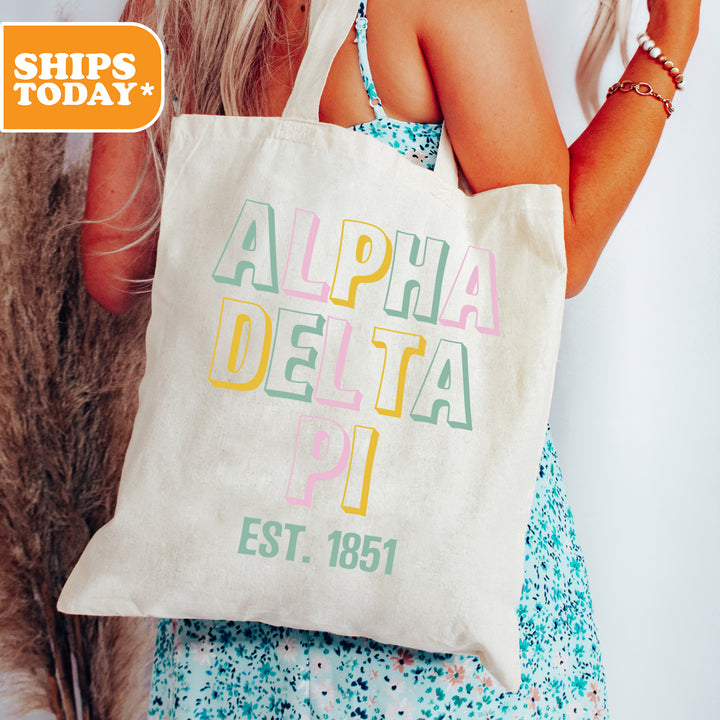 a woman holding a white bag with the words alpha delta on it