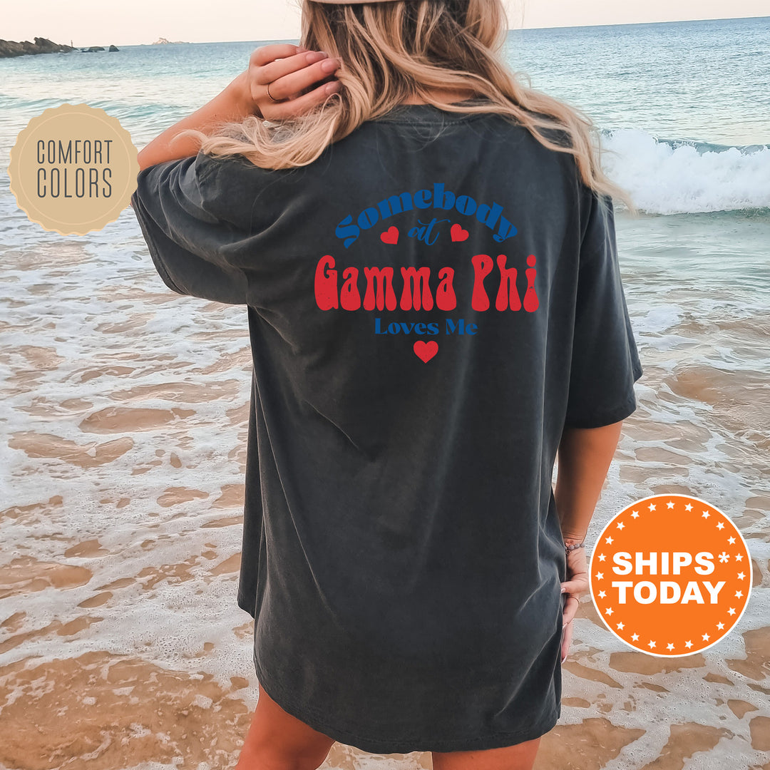 a woman standing on a beach wearing a black shirt