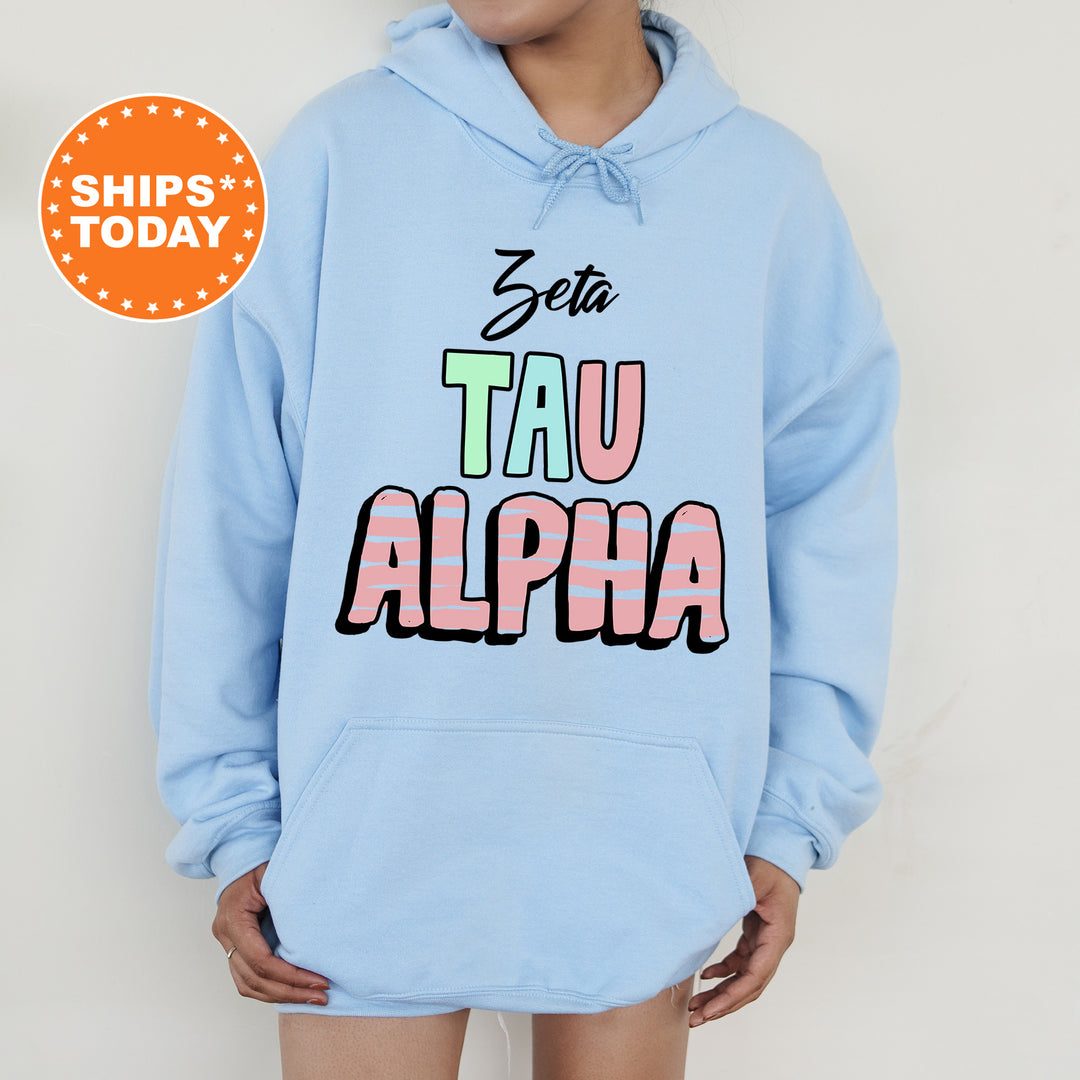 a person wearing a blue hoodie with the words tau alpha printed on it